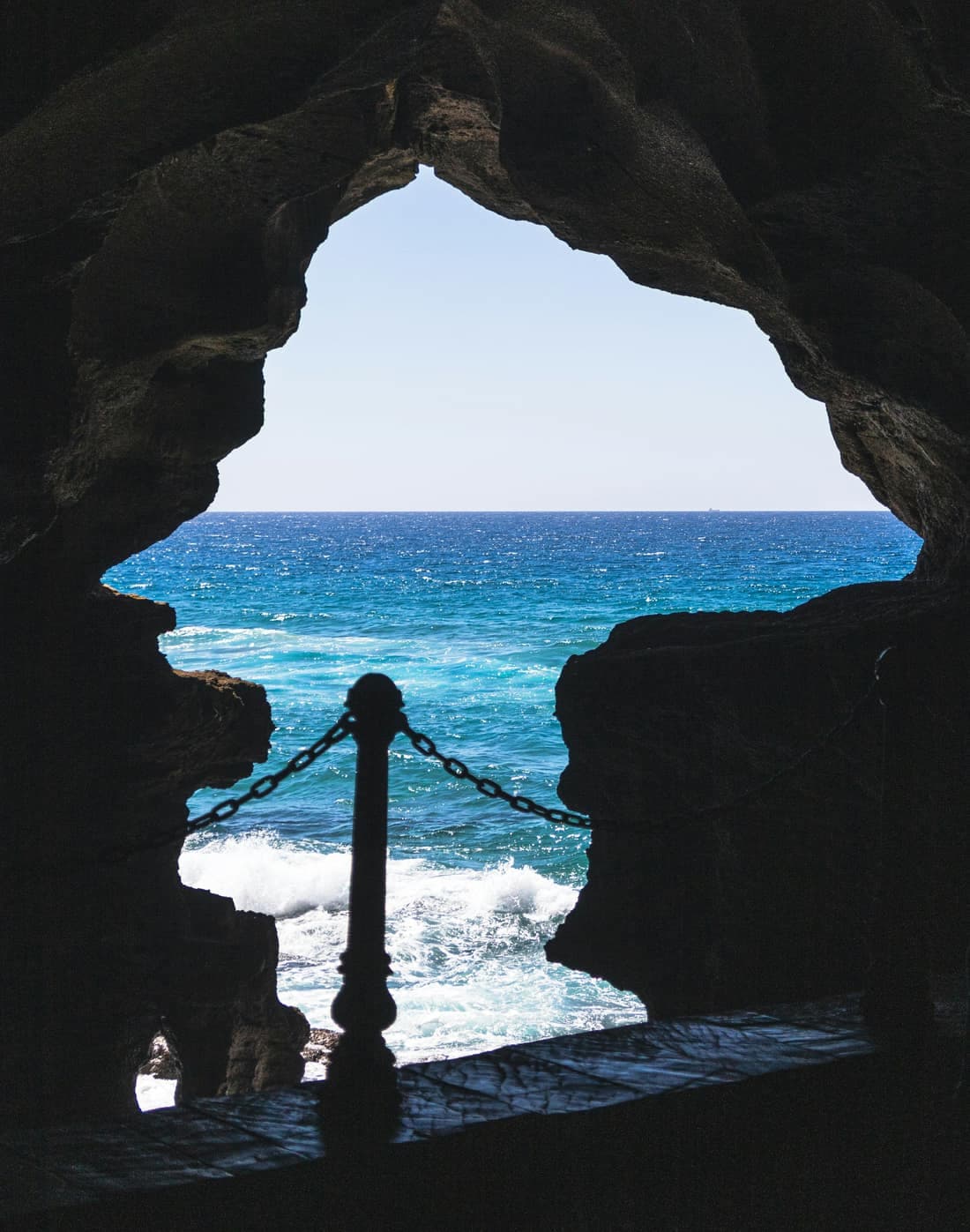 The Atlantic seen through the rock opening of a sea cave near Tangier, waves breaking below.